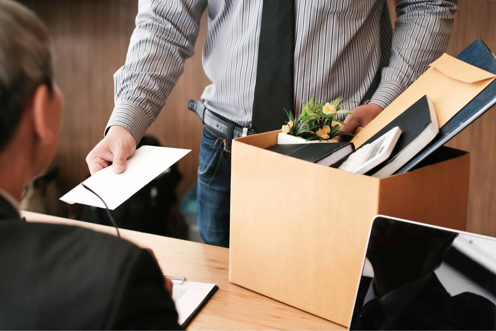 man handing in letter of resignation